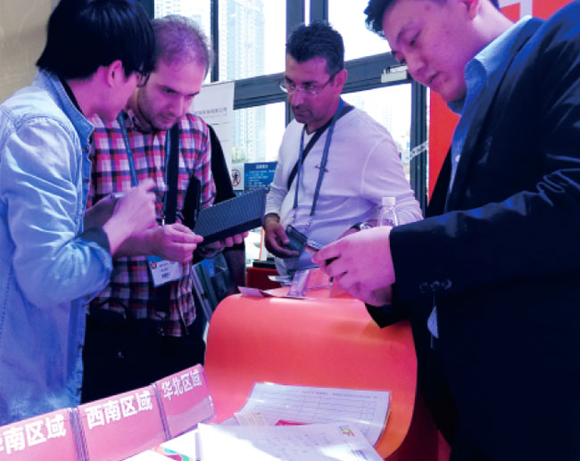 广州琶洲国际会展中心B区酷游九州工作人员与前来参观朋友交谈